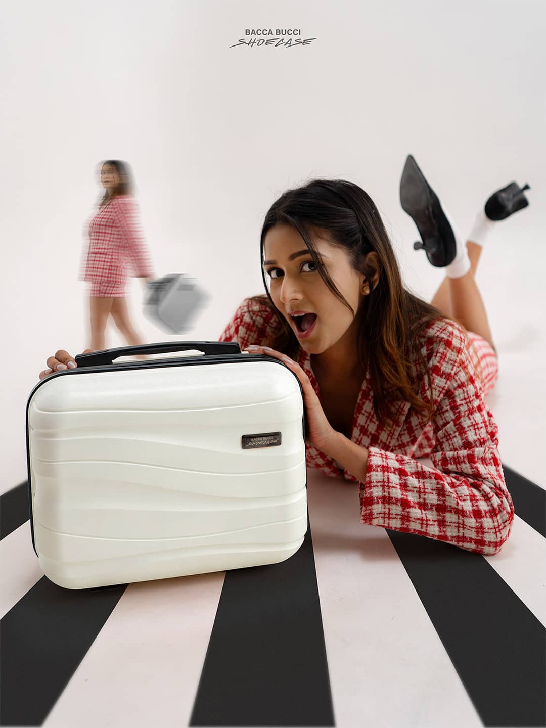 Woman holding a bacca bucci white shoecase on a black and white striped floor.